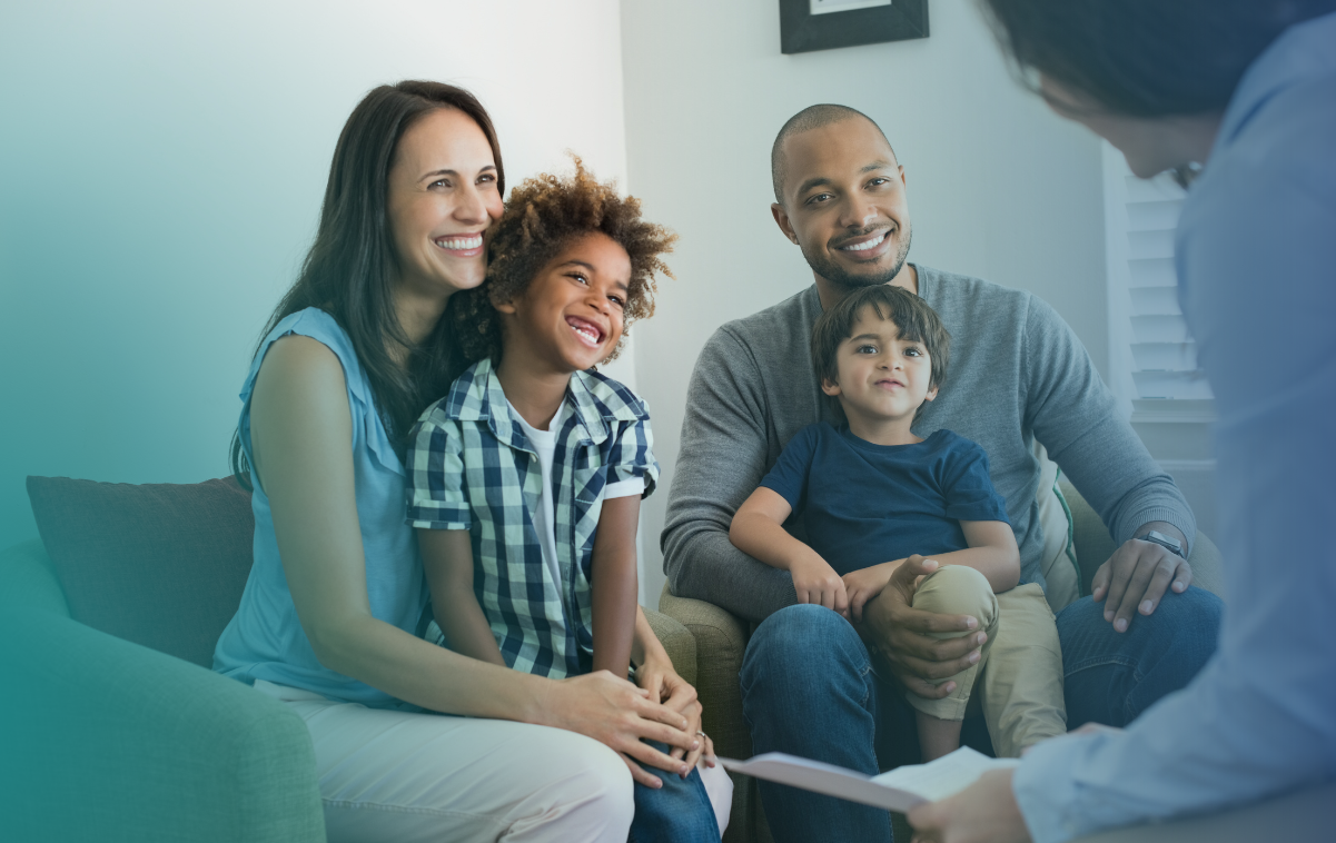 Imagem de uma família feliz sendo consultada por um médico em um consultório médico.